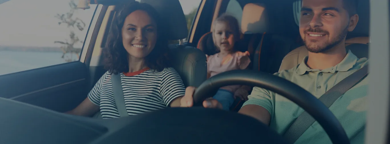Familia sonriente viajando en su auto